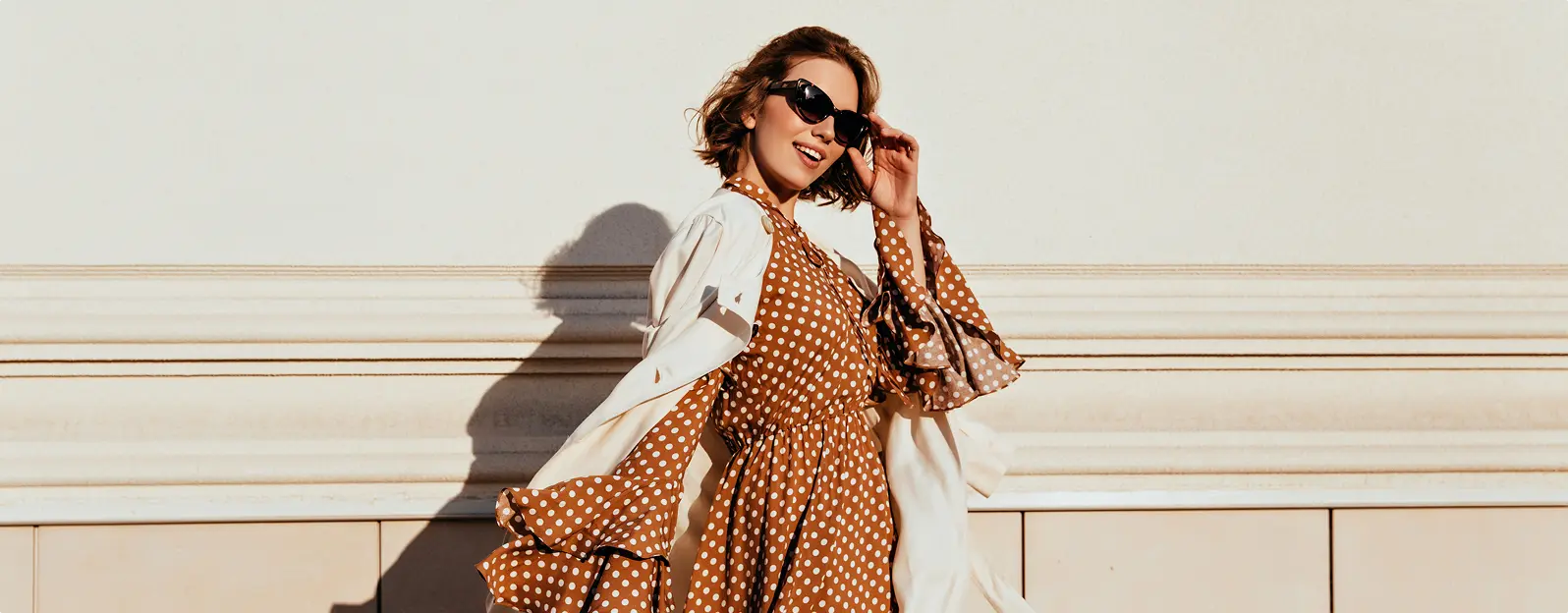 Mergina su akiniais nuo saulės, besišypsanti